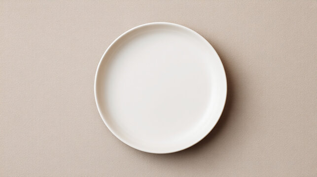 A simple white ceramic plate centered on a light beige background in a studio setting with soft lighting