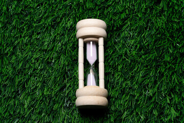 Wooden Hourglass on Green Grass