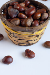 Fresh chestnuts in a wooden basket.White background.