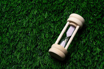 Wooden Hourglass on Green Grass