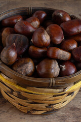 Fresh chestnuts in a wooden basket.