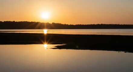 Beautiful sunset over calm water with the sun reflecting its golden light on the surface