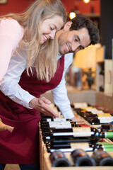 Fototapeta premium male sommelier helping woman to buy bottle of wine