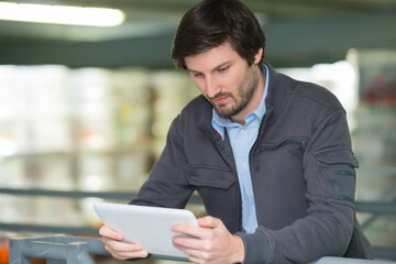 man using digital tablet in shop