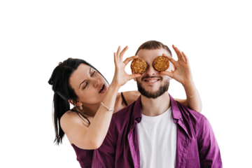 Couple on transparent background having fun with cookies over eyes, playful and joyful moment