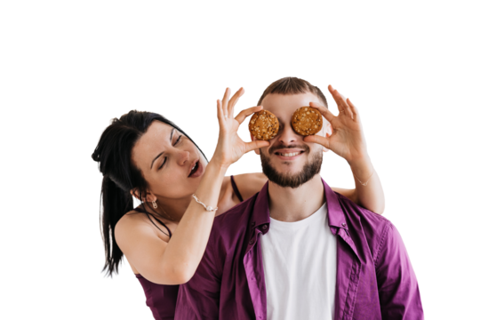 Couple on transparent background having fun with cookies over eyes, playful and joyful moment