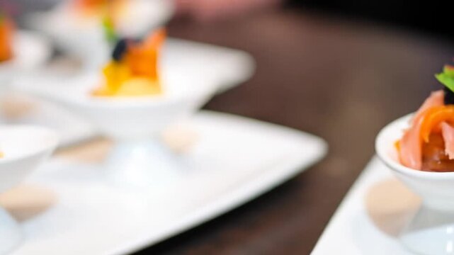 Close-up of bite-sized appetizers with caviar, roe, and garnish in small, elegant white dishes