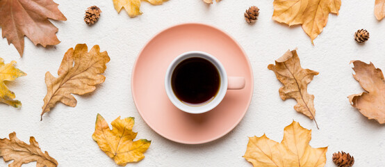 Flat lay composition with colorful Autumn cup of coffee and leaves on a color background. top view