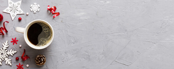 Delicious fresh festive morning coffee in a ceramic cup with little wrapped gifts, ornament and xmas toy. Cup of coffee and new year toys