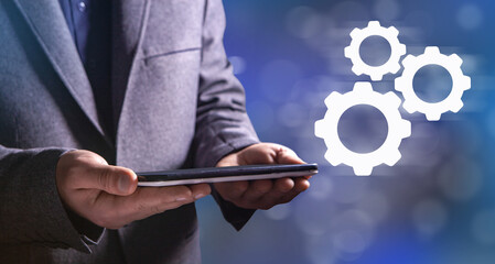 Businessman and blue gear icon on screen. Concept of the mechanism