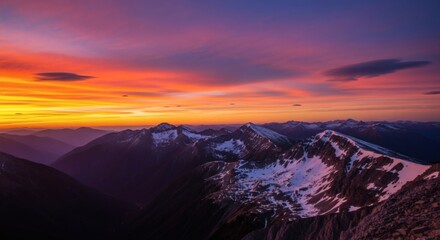 Breathtaking mountain vista captures a vibrant sunrise with snow-capped peaks against a fiery sky