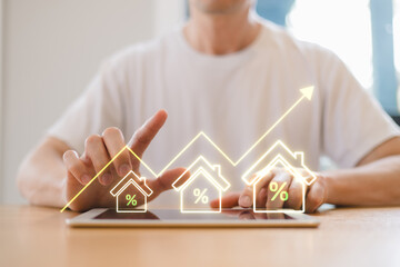 Real estate investor analyzing property growth and interest rate trends on tablet with digital graph interface. Housing market investment financial technology concept.