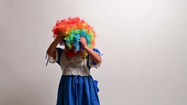 Little girl in a clown costume performing on white background
