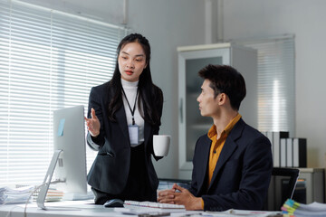 Businesswoman discussing project with male office colleague