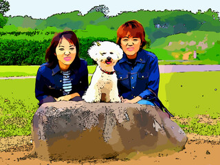 公園の岩の上のビションフリーゼと女性二人