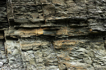 Black yellow rock texture. Mountain surface. Close-up. Gray stone background with copy space for design. Wide banner. Panoramic.