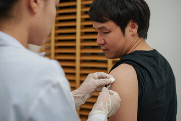 doctor holding syringe and making injection vaccine to patient