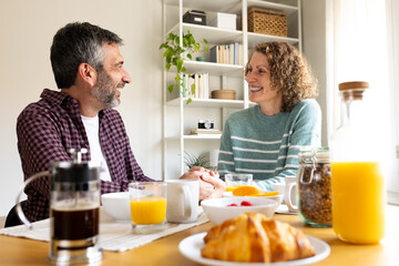 Happy couple enjoying a relaxed breakfast together at home