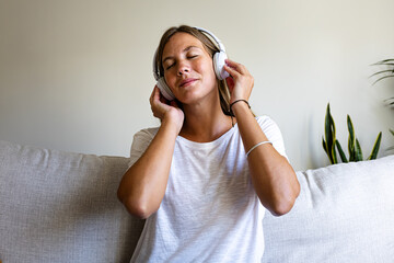 Young woman enjoying music using headphones.