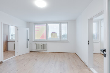 Empty apartment room displaying fresh renovation and laminate flooring
