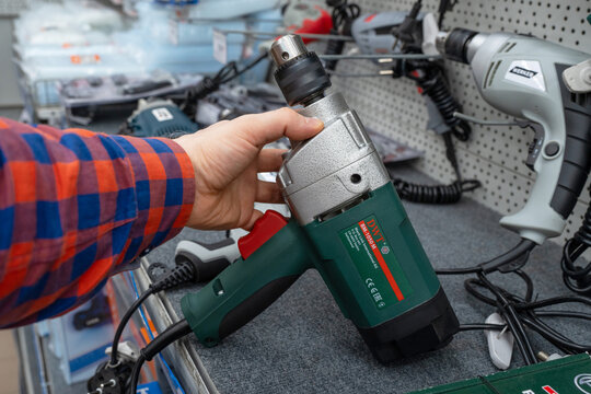 DWT brand electric drills are sold in the power tool store. Man shopping for electric drill in hardware store close-up. Minsk, Belarus - june 26, 2022