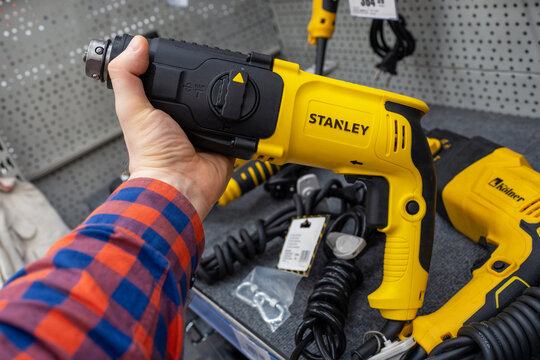 Stanley brand electric drills are sold in the power tool store. A customer selects an electric drill. Electric drill in hand. Minsk, Belarus - june 26, 2022