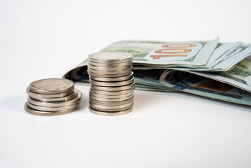 Stacked coins with folded cash money on clean surface. Symbol of saving, investment, and smart financial management.