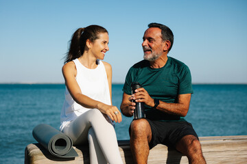 Middle-aged man and woman relaxing outdoors by the sea