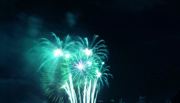 Stunning vibrant arctic blue fireworks exploding in the night sky
