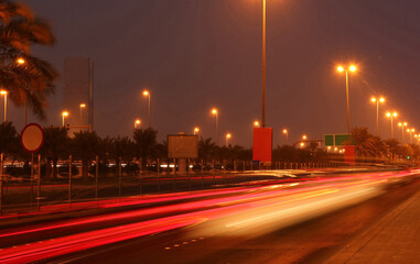 Urban street in the city at night with vibrant color car light trails