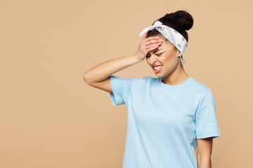 Young sad woman of African American ethnicity wear blue t-shirt headscarf casual clothes put hand on face facepalm epic fail mistaken omg gesture isolated on plain beige background. Lifestyle concept.