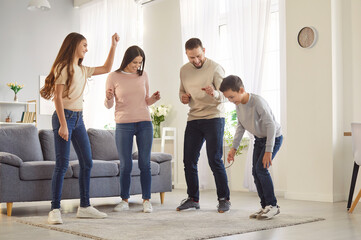 Happy family with two kids dancing, having fun, playing and enjoying leisure time together at home....