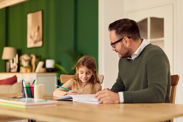 Obraz premium Father Helps Daughter With Homework At The Table In A Warm Green Home Setting