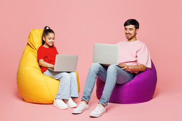 Full body young parent IT man with child girl wear red clothes. Daddy little kid daughter sit in...