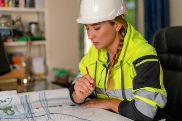 Woman builder professional architect working on architectural plans blueprints in office