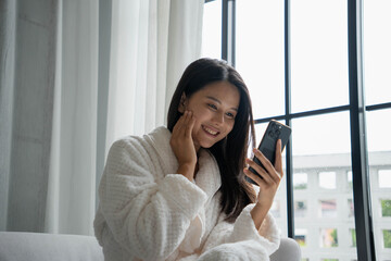 Young Asian Woman Using Phone to Research Beauty Tips
