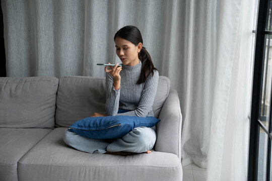 Woman talking with friend by using speaker phone