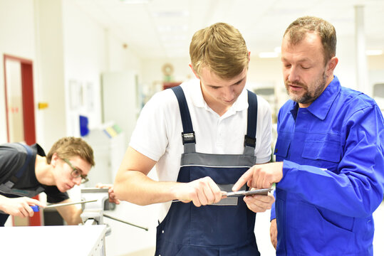 Group of young people in mechanical vocational training with teacher