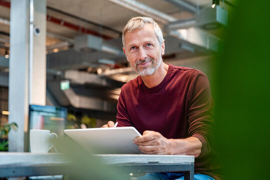 Portrait of a businessman in modern office using tablet in a business work situation