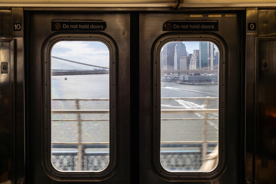 View of Manhattan and Brooklyn Bridge through subway window in New York City