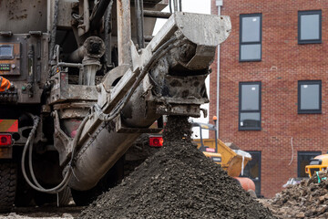 Mixer truck delivered concrete on construction site and unloaded on ground