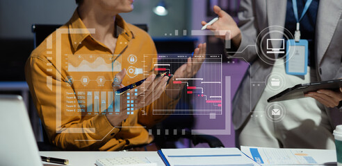 Businessman hand Project manager working overtime and update tasks and Gantt chart scheduling virtual diagram.with laptop in office.