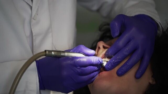 Dentist surgeon is using a variety of instruments to remove a patient old bridge in preparation process for new implant prosthetics teeth
