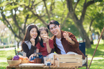 Happy asian family picnic in park, weekend lifestyle outdoors.