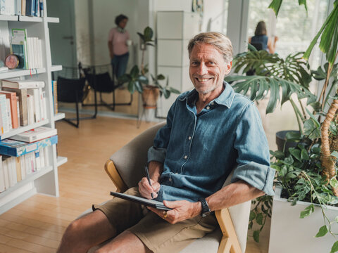 Creative man using tablet computer in modern home living room