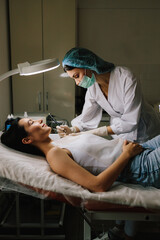 Radiofrequency mole removal under clinical conditions. dermatologist performs precise radio wave mole removal using radiofrequency surgery. Close-up of radio wave dermatologic mole excision.