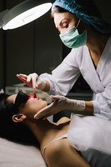 Aesthetic laser removal of nevi and benign growths. Dermatologist performs precise laser removal of...