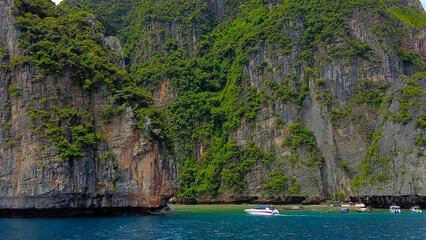 Traveling in Thailand. Phi Phi Islands. Maya Bay from the other side, numerous boats with tourists on the shore.