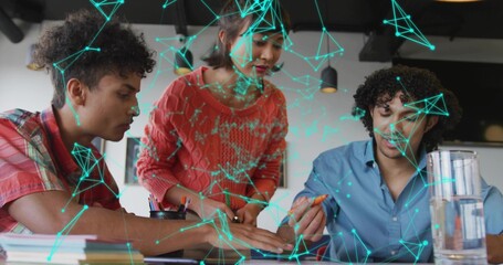 Leaning coworkers marking printed documents on desk in office, colored markers and network overlay
