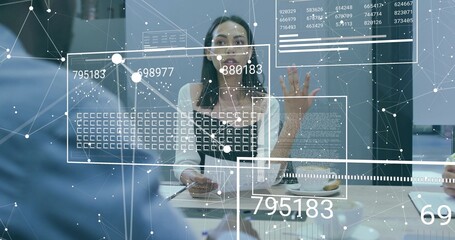 Speaking businesswoman gesturing to colleagues in conference room, with coffee cup and data overlay